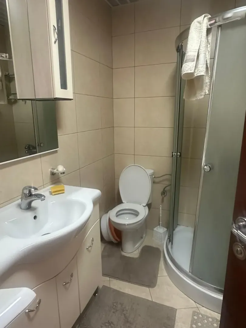 Manje kupatilo sa umivaonikom, wc šoljom i tuš kabinom.