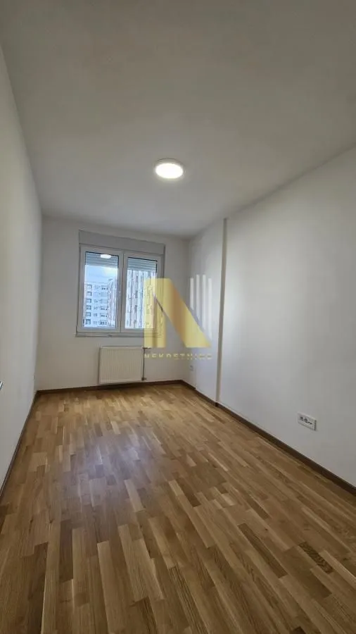 Empty room with parquet flooring and white walls.