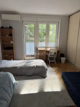 Nameštena spavaća soba sa krevetom, radnim stolom, plakarom i izlazom na balkon. - image 10