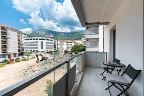 Small covered balcony with outdoor seating and a city view. - image 2