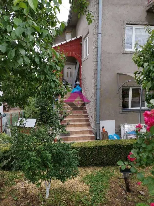 Spoljašnji izgled kuće sa stepeništem i dvorištem.
