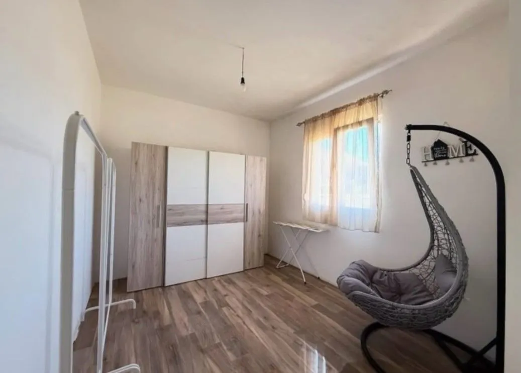 Furnished bedroom with a wardrobe and hanging chair.