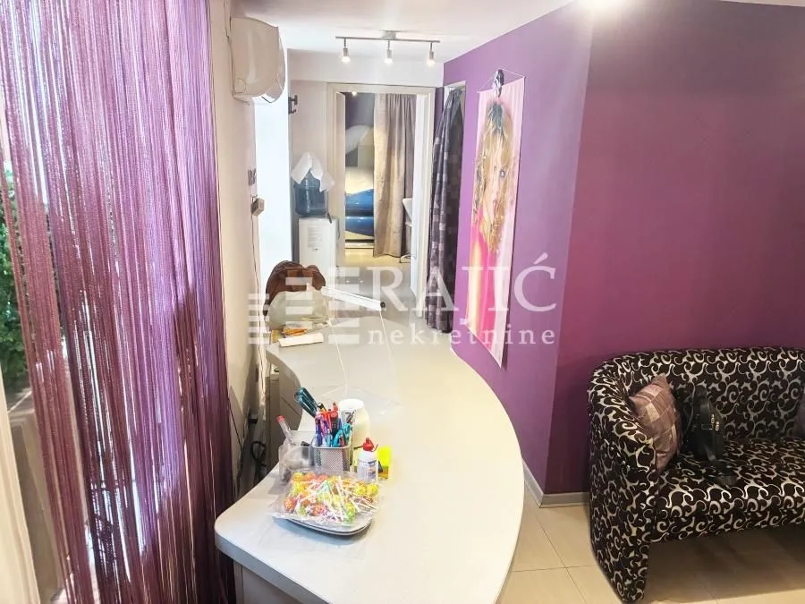 Living room with a desk and a purple wall.