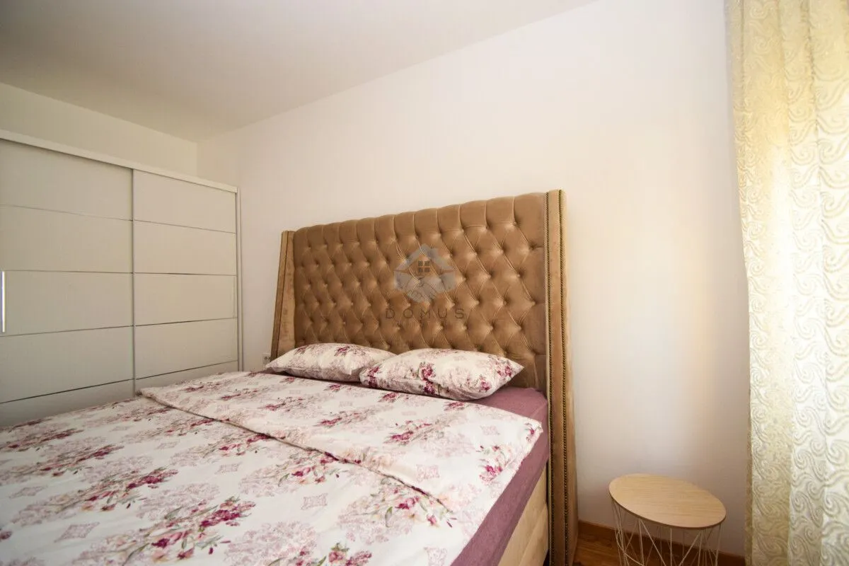 Bedroom with a double bed featuring a tufted headboard and a white wardrobe.