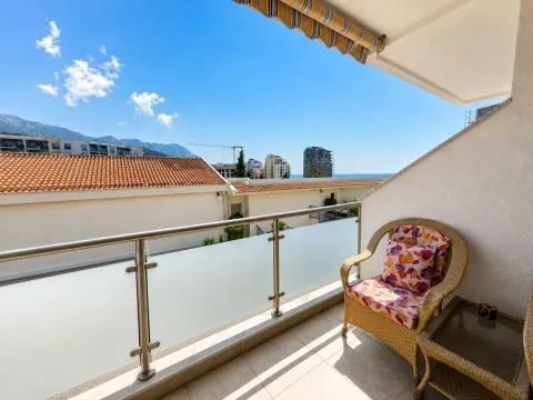 Namješten balkon sa foteljom i pogledom na naselje i more. - image 3
