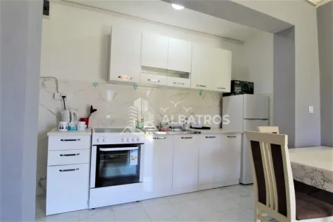 Kitchen with white cabinetry, stove, and refrigerator adjacent to the dining area. - image 6