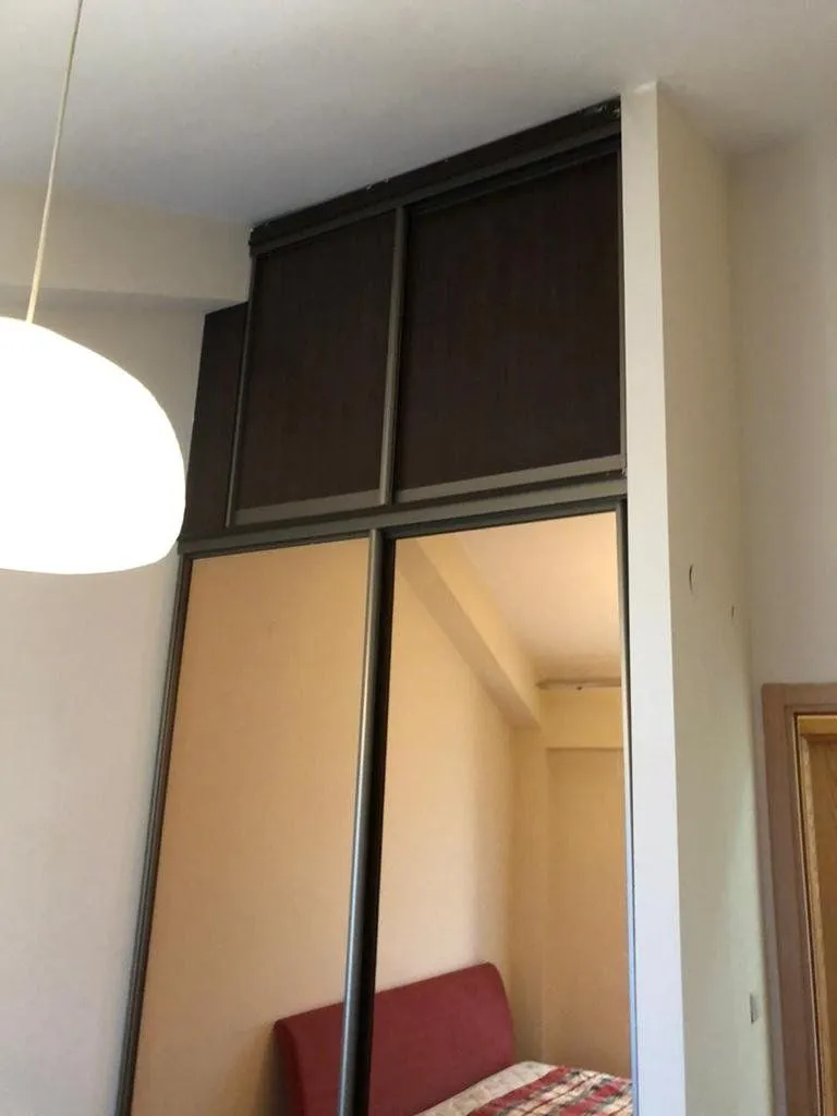 Bedroom featuring a large built-in wardrobe with sliding doors and a mirror.