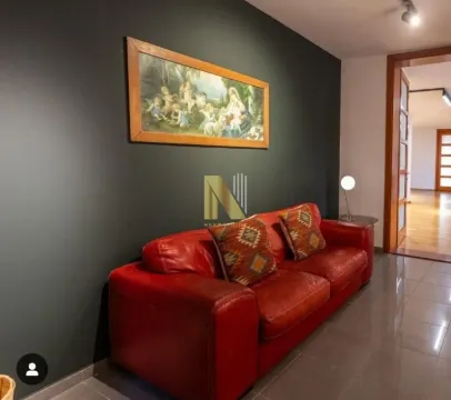 Living room with a red leather sofa and a dark accent wall. - image 12