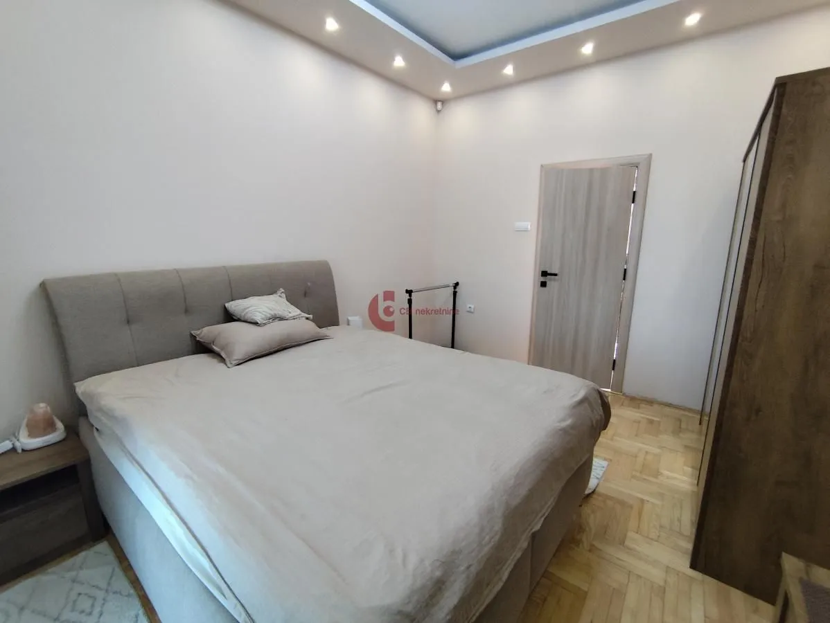 Bedroom with a double bed, wardrobe, and parquet flooring.