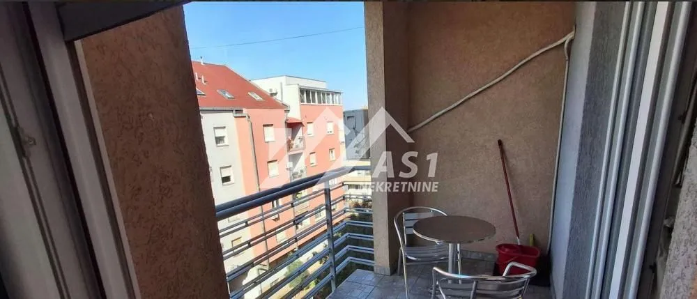 Manji namešteni balkon sa pogledom na okolne zgrade.