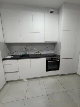 Modern white kitchen with a black countertop and a built-in oven. - image 5