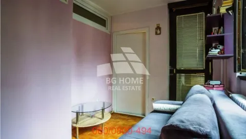 Dnevna soba sa kaučem, stočićem i roze zidovima. - image 2