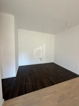 Prazna prostorija sa tamnim podnim pločicama i belim zidovima. - image 5