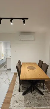 Trpezarija sa drvenim stolom i stolicama na tepihu. - image 12