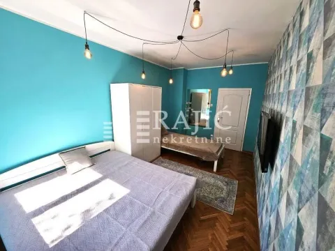 Bedroom with a bed and blue wallpaper on the wall. - image 11