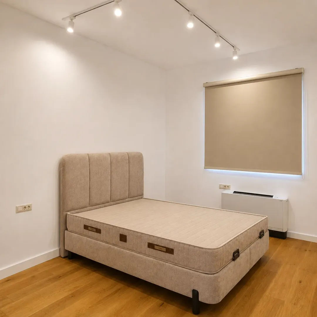 Bedroom with a double bed and a window with a roller blind.