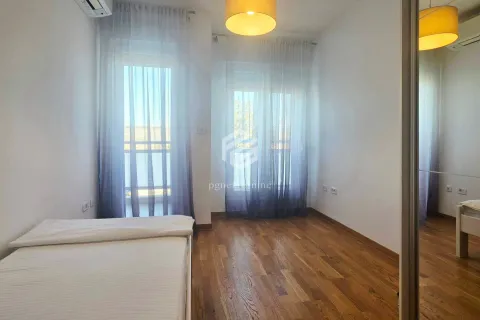 Bedroom with a bed, wooden flooring, and access to the terrace. - image 10