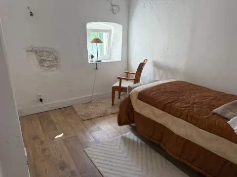 Manja spavaća soba sa krevetom, drvenim podom i prozorom. - image 11
