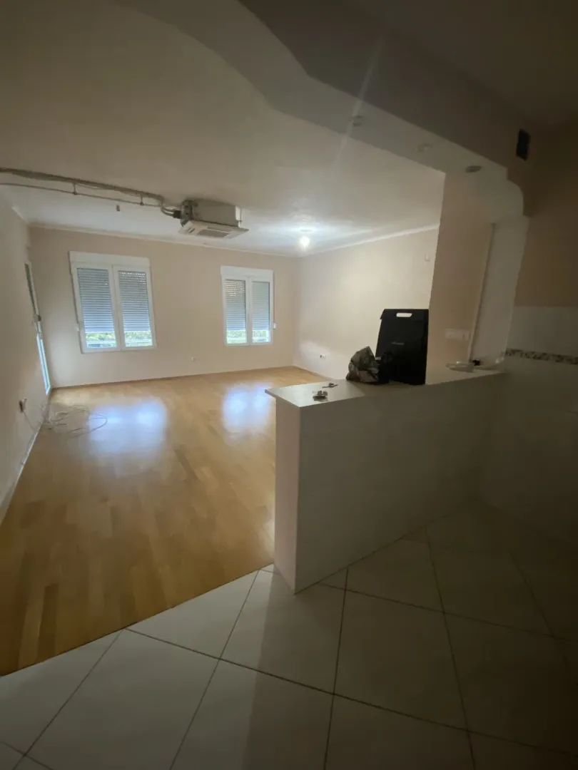 Prazna soba sa svijetlim podovima i šankom.