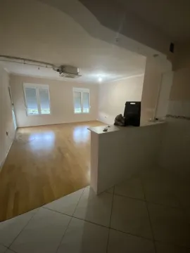 Prazna soba sa svijetlim podovima i šankom. - image 2
