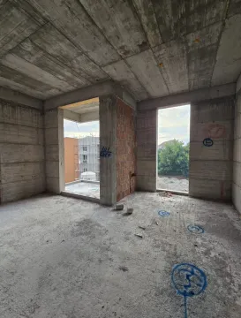 Nepotpun prostor u sivoj fazi sa betonskim stubovima i otvorima za vrata. - image 12