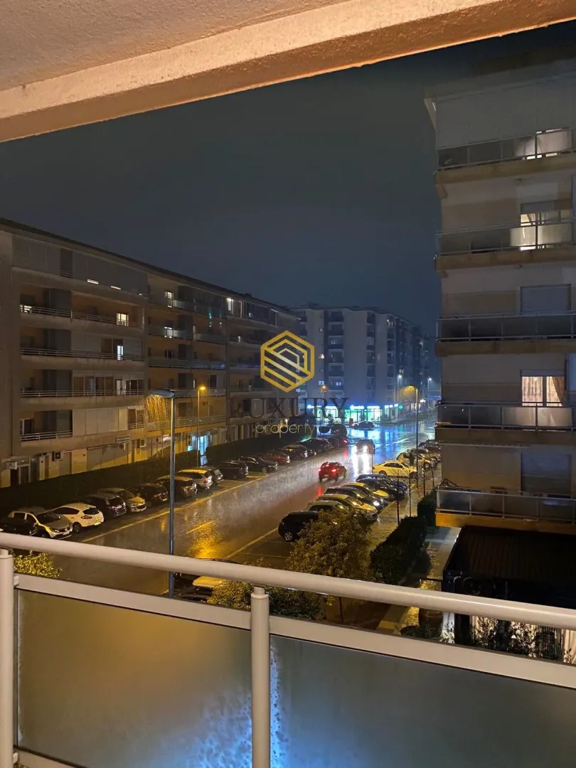 Noćni pogled sa terase na gradsku ulicu i zgrade.