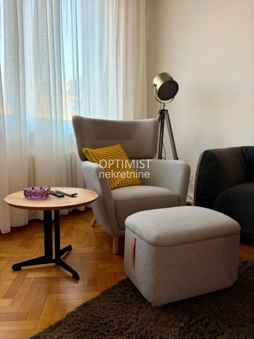 Comfortable armchair with an ottoman and a small table in the living room.