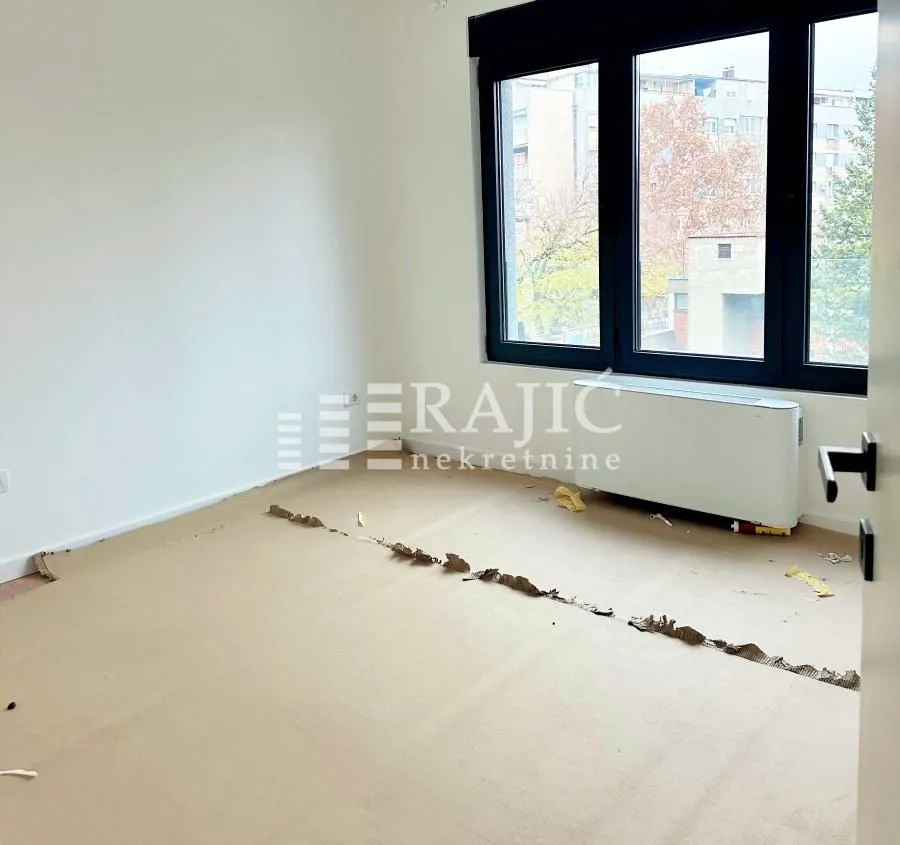 Empty room with protective paper on the floor and a large window.