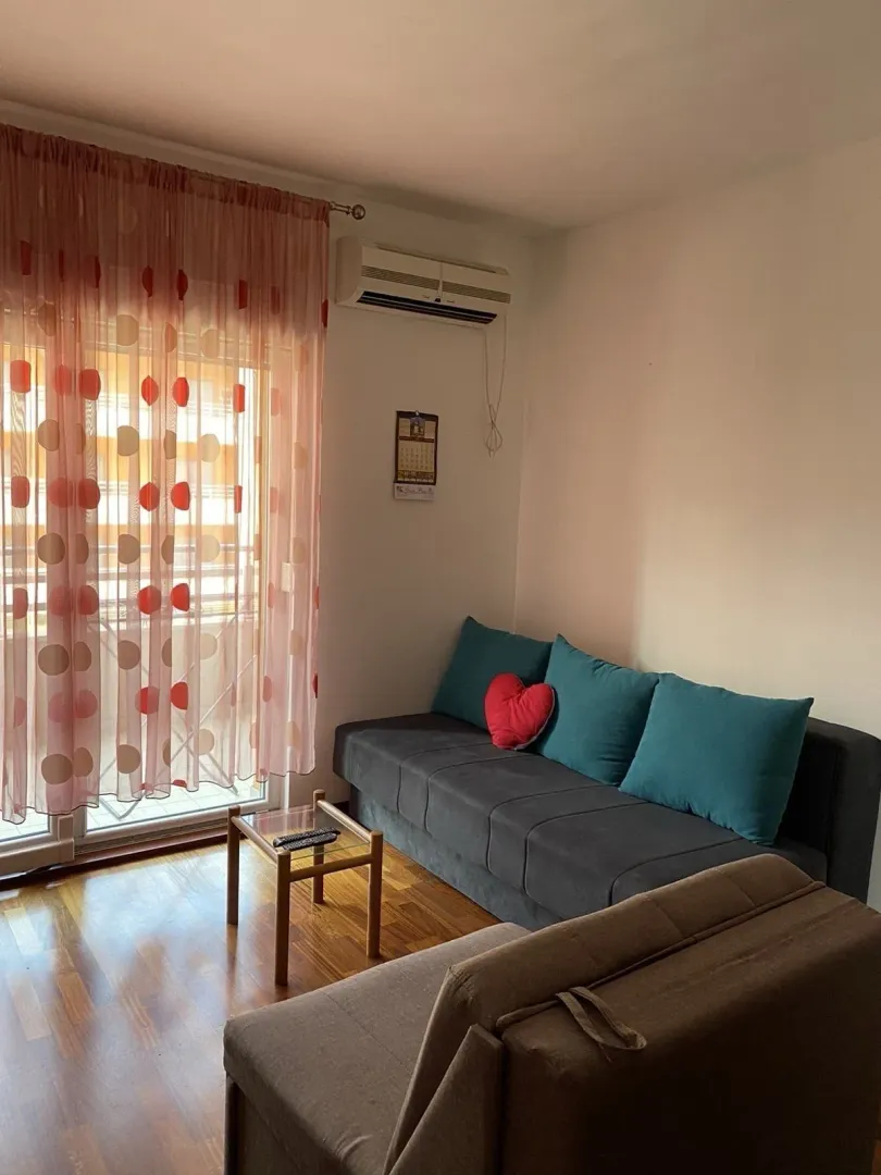 Living room with sofas and balcony access.