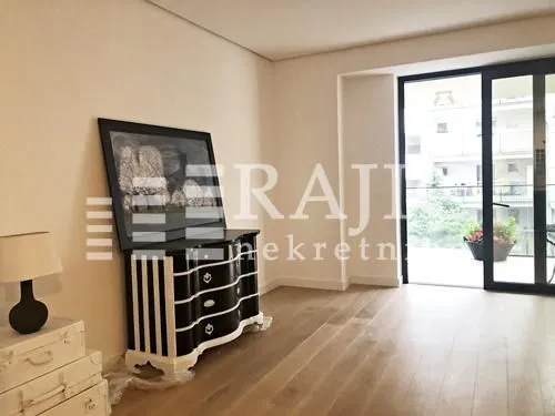 Living room with a chest of drawers, a painting, and balcony access.