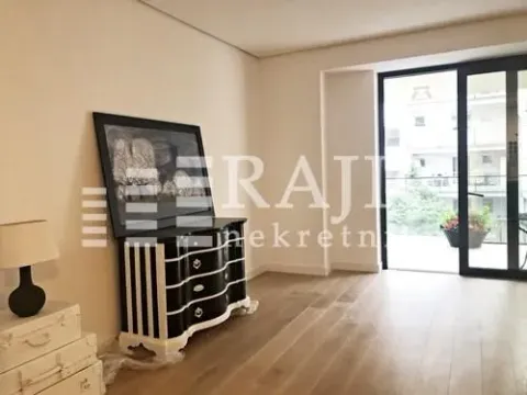Living room with a chest of drawers, a painting, and balcony access. - image 20