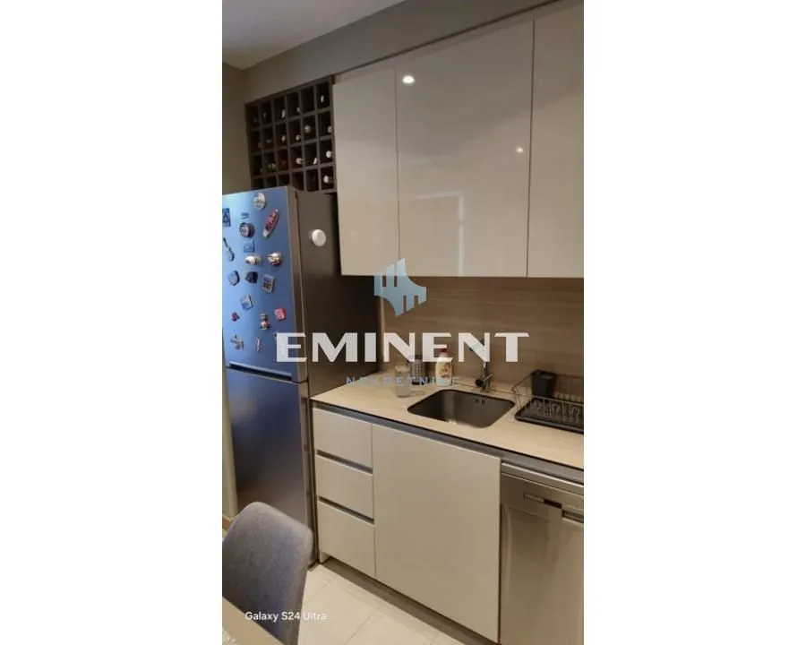 View of a section of the kitchen with cabinetry and a refrigerator.