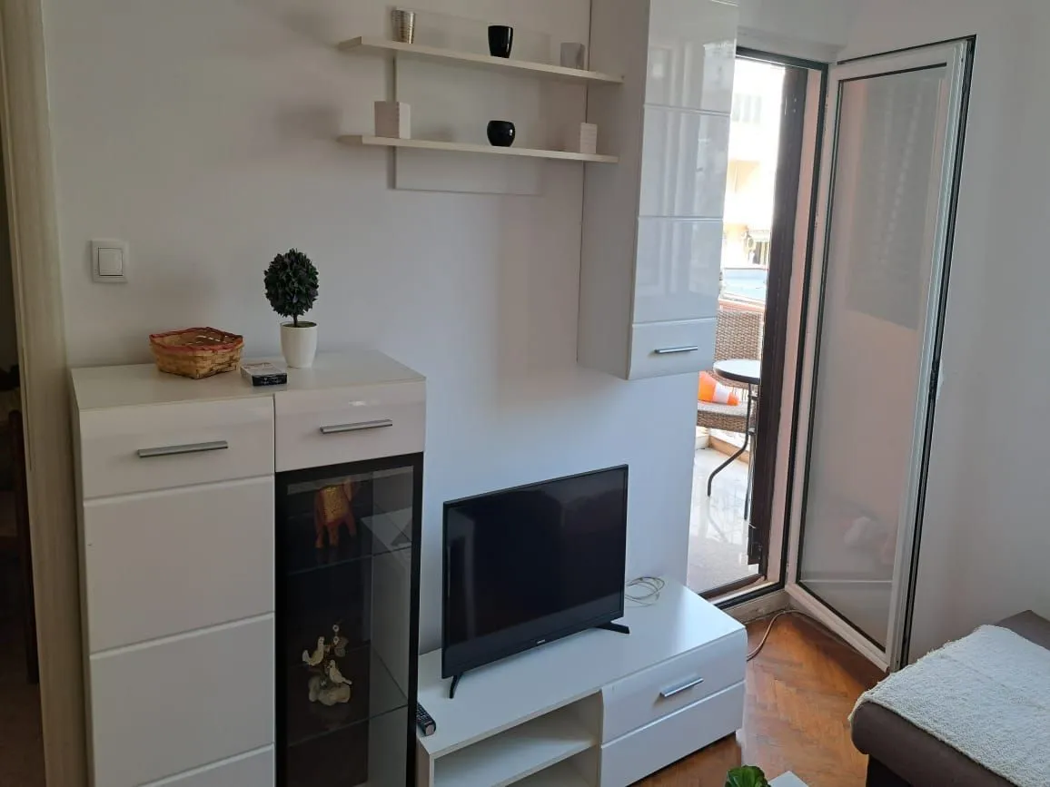 Living room with white furniture and access to the terrace.