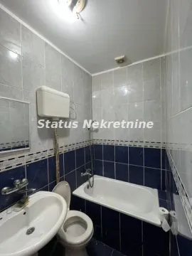 Manje kupatilo obloženo pločicama sa kadom, umivaonikom i WC šoljom. - image 5