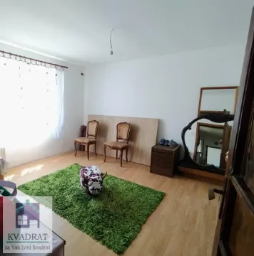 Dnevna soba sa drvenim podom, stolicama i zelenim tepihom. - image 9