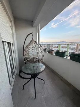 Namtještena terasa sa stolom, visećom foteljom i pogledom na grad. - image 7