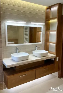 Modern bathroom with double sinks, large mirror and wooden elements. - image 18