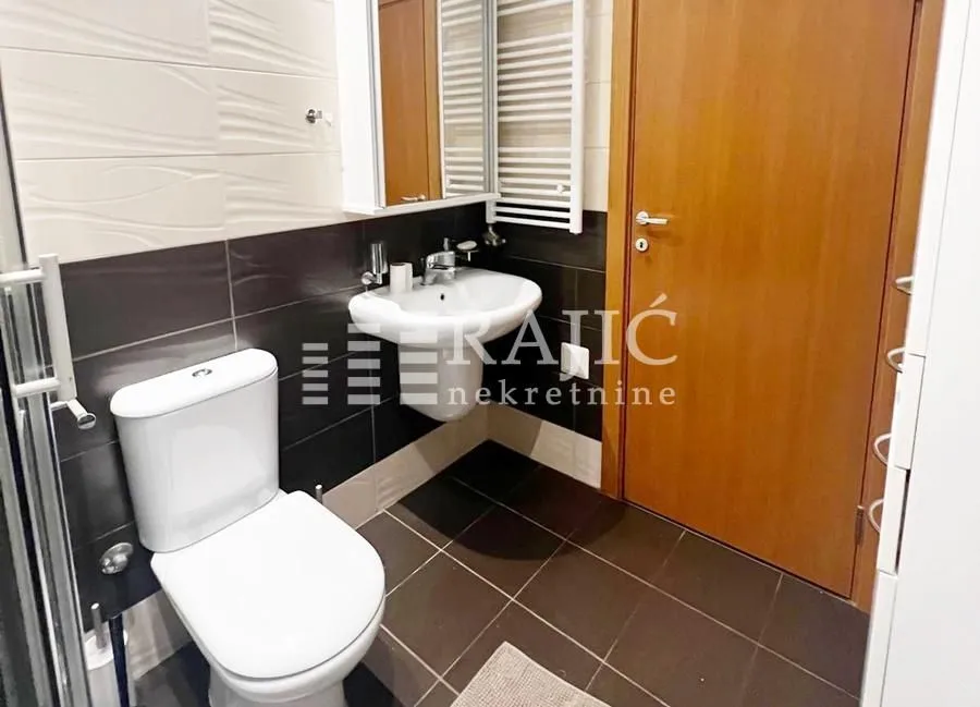 Modernly equipped bathroom with sanitary ware and wooden doors.