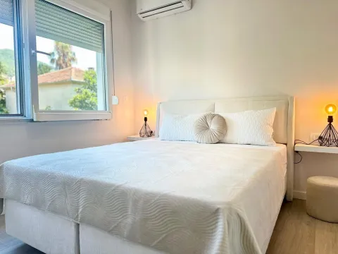 Bright bedroom with a double bed and bedside lamps. - image 6