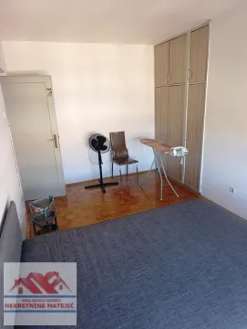 Bedroom with a bed, built-in wardrobe, and wooden flooring. - image 18