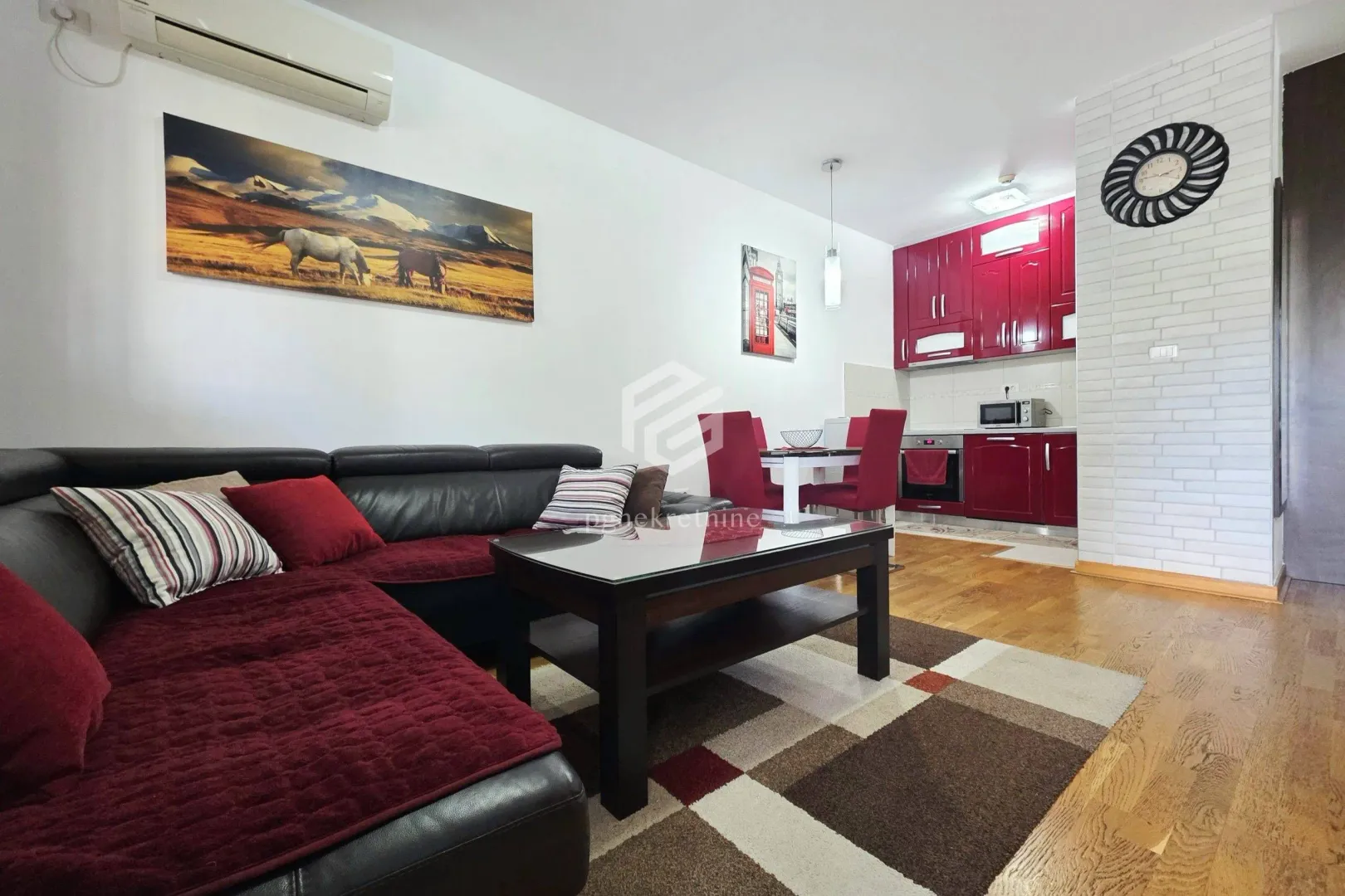 Living room with a sofa and a dining area integrated with the kitchen.