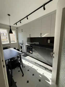 Kitchen with dining area, built-in units, and a washing machine. - image 3