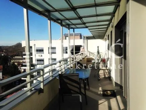 Spacious covered terrace with a table, chairs, and a view of the surroundings.