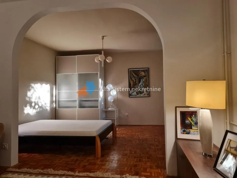 View from the hallway into the bedroom with a bed and wardrobe.
