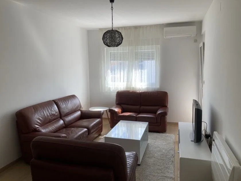 Living room with brown leather seating and a white coffee table.
