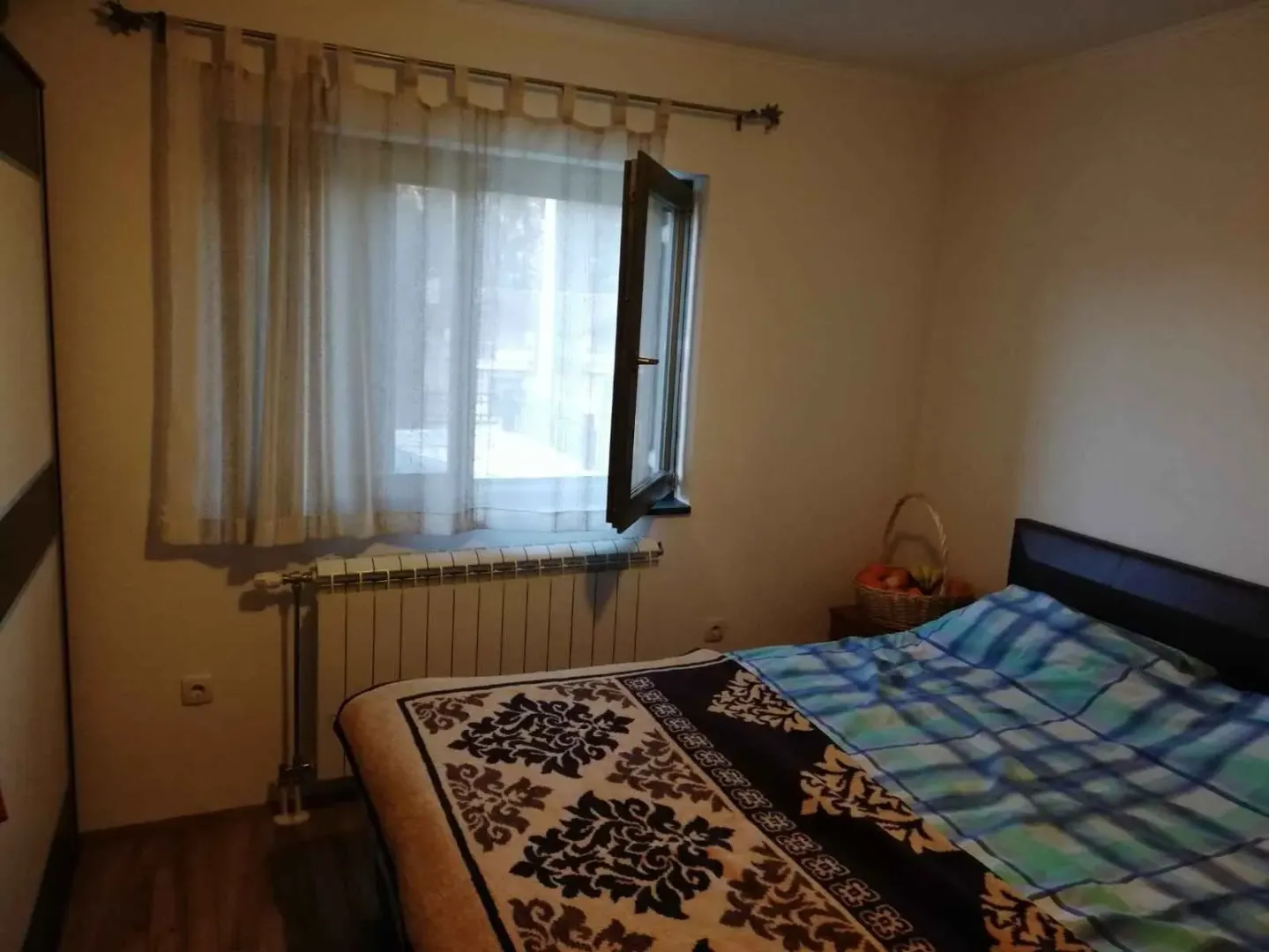 Spavaća soba sa bračnim krevetom i prozorom.