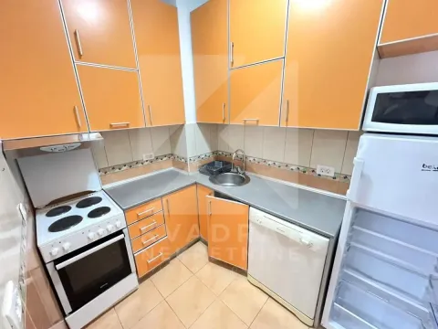 Manja kuhinja sa narandžastim elementima i osnovnim kućnim aparatima. - image 4