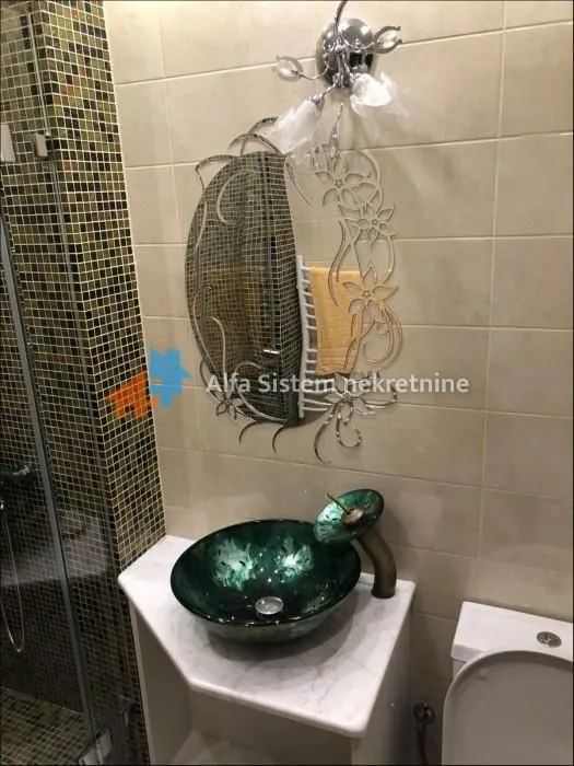 Bathroom with a washbasin, mirror and ceramic tiles.