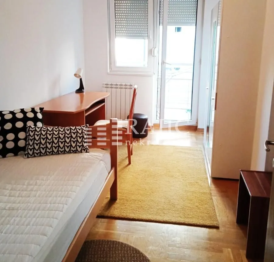 Furnished bedroom with a bed, desk, and access to the terrace.