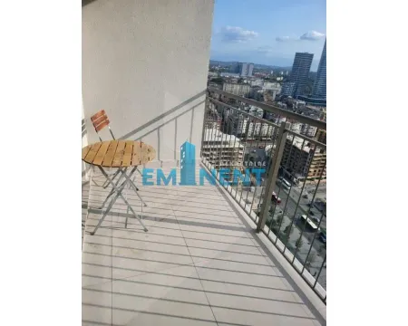 Small furnished balcony with a table, chair, and city view. - image 10